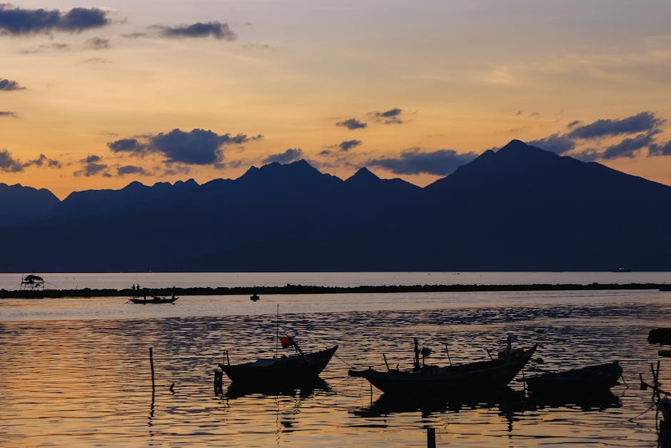 Cảnh hoàng hôn yên bình với bóng dáng những chiếc thuyền và dãy núi ở Thành phố Hồ Chí Minh, Việt Nam.