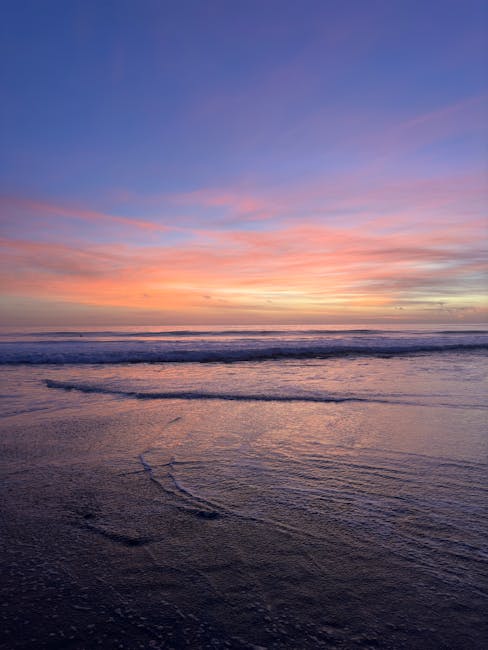 Cảnh hoàng hôn ngoạn mục trên bãi biển Malibu với những màu sắc sống động phản chiếu trên sóng biển.