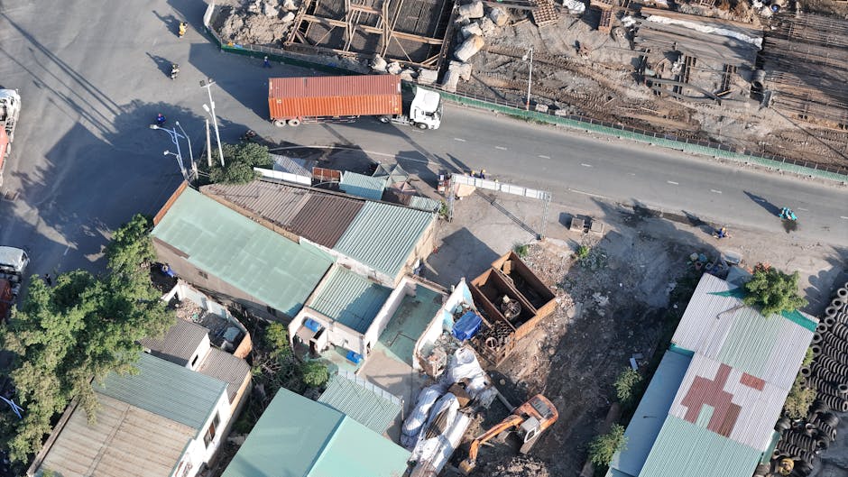 Ảnh chụp từ trên không công trường xây dựng và xe container trên đường ở Thủ Đức, Việt Nam.